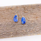 Pair of blue stone earrings on a wooden surface