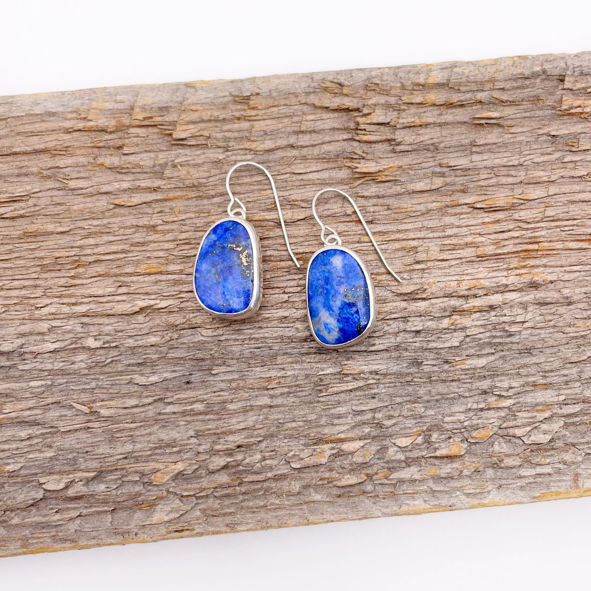 Pair of blue stone earrings on a wooden surface
